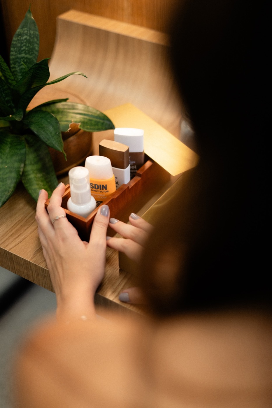 Mãos organizando produtos de cuidado com a pele